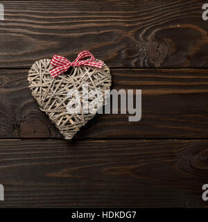 Konzept der Valentinstag. Wicker-Herzen auf dunklem Holz. Stockfoto