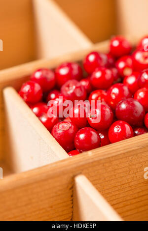 Schwedische Preiselbeeren in Holzkiste. Nahaufnahme von roten Beeren. Stockfoto