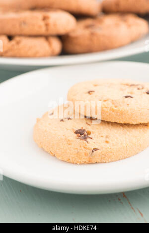 Chocolate Chip Cookies auf Platte in Nahaufnahme. Süße Speisen, Nachtisch oder Snack. Die Cookies werden auf einem Küchentisch serviert. Stockfoto