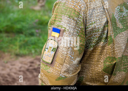 PABRADE / Litauen - 8. August 2016: Ukraine Nationalflagge mit einem Armee-Patch auf eine militärische Feldjacke Stockfoto