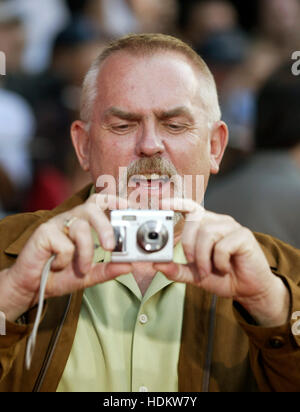 Schauspieler John Ratzenberger, wer ist die Stimme des Zeichens "The Underminer", nimmt ein Foto des Fotografen bei der Premiere des neuen Animationsfilm von Pixar, "The Incredibles" am El Capitan Theatre in Los Angeles, 24. Oktober 2004. Der Film beginnt in den Vereinigten Staaten am 5. November. Foto von Francis Specker Stockfoto