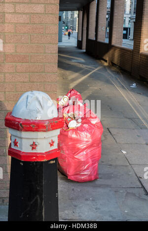 Rosa Abfallsäcke und anderen Wurf in einer zentralen London Straße warten Sammlung Stockfoto