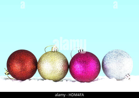 Bunte Kugeln auf dem Eis mit einem grünen Hintergrund. Stockfoto