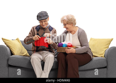 Ältere Frau, die einem älteren Mann beizubringen, isolierten auf weißen Hintergrund zu stricken Stockfoto