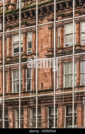 Ein modernes Bürogebäude in der Innenstadt von Glasgow spiegelt der Vintage Buntsandstein Mietskasernen, die einst die Stadt beherrscht. Stockfoto