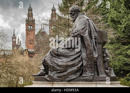 Eine Statue von Lord Kelvin befindet sich im Kelvingrove Park im Westend von Glasgow mit Kunstgalerie und Museum im Hintergrund. Stockfoto