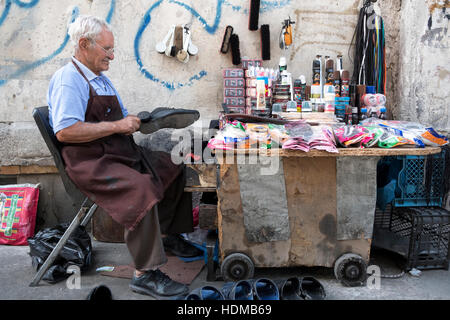 Eine Straße Verkäufer repariert Schuhe zu einem Stall in Teheran, Provinz Teheran, Iran. Stockfoto