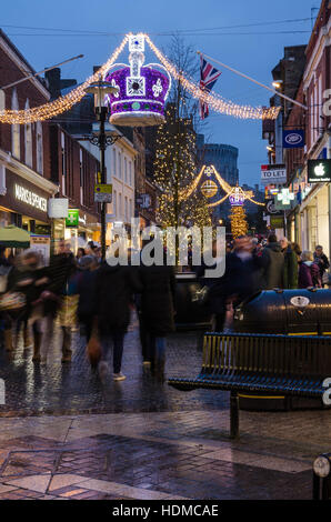 Menschen beeilen um ihre Weihnachtseinkäufe wie Nacht in Peascode Street, Windsor, Berkshire, UK zieht zu tun. Stockfoto