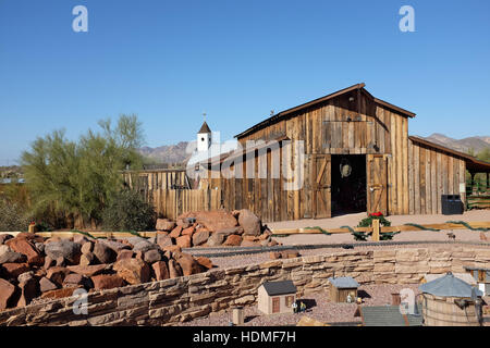 Drittletzter Scheune und Modelleisenbahn mit Elvis Memorial Chapel im Hintergrund im Superstition Mountain Museum in Apache Junction, Ariizona. Stockfoto