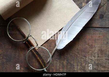 Papier und Feder Stift in der Nähe von Brille auf schönen alten hölzernen Hintergrund Stockfoto