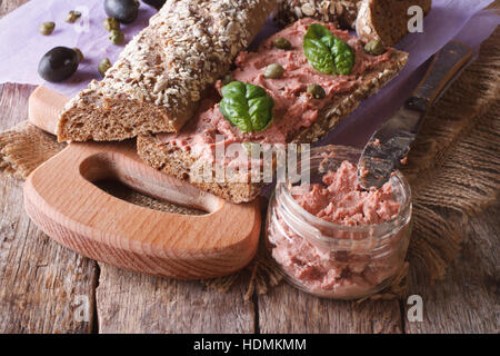 Sandwich mit Gans Pastete, Kapern und Basilikum Nahaufnahme auf Schneidebrett. horizontale Stockfoto