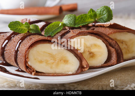 Schokolade Pfannkuchen mit Bananen Füllung Nahaufnahme auf einem weißen Teller. horizontale Stockfoto