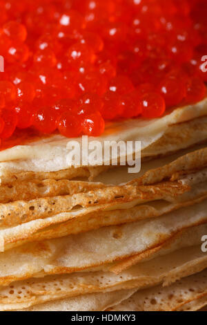 Ein Haufen von dünne Crepes mit rotem Kaviar Makro. vertikale, rustikalen Stil Stockfoto