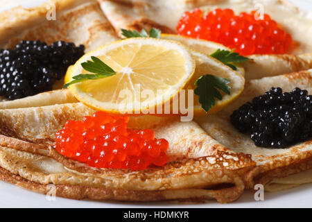 Dünne Pfannkuchen mit roten und schwarzen Kaviar auf einer horizontalen Platte-Makro Stockfoto