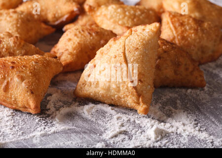 Ein Haufen Samosas auf einem bemehlten Tisch backen. Horizontale Nahaufnahme Stockfoto