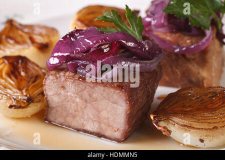 Rindfleisch gegrillt und karamellisierten Zwiebeln auf einem weißen Teller-Makro. horizontale Stockfoto