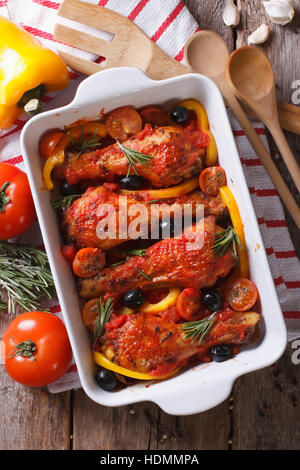 Hähnchenschenkel gebacken mit Gemüse in Tomatensoße. vertikale Ansicht von oben Stockfoto