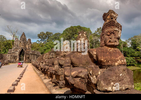 Asura Statuen halten die Cobra Schlange Gottheit Naga am Straßenrand vor dem Südtor von Ta Prohm, Kambodscha. Stockfoto