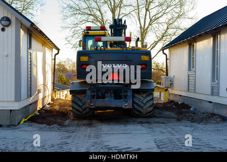 Bokenas, Schweden - 12. Dezember 2016: Dokumentation der Baustelle. Die Rückseite eines Volvo-Baggers abgestellt zwischen zwei neu errichteten touristischen cabi Stockfoto