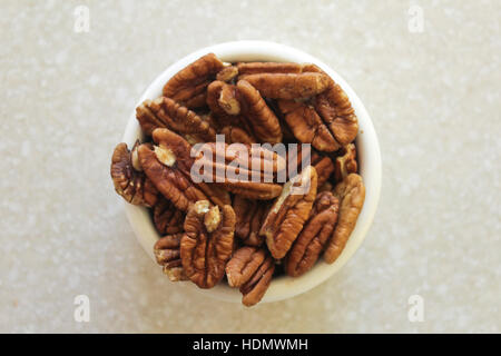 Köstliche Pekannüsse in einem Container auf einer Küchenarbeitsplatte, bereit, als Snack oder in ein Lieblingsrezept zu genießen! Finden Sie unter Portfolio für andere ähnliche Fotos in Stockfoto