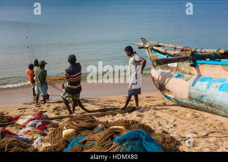 GALLE, SRI LANKA - 9. Dezember 2016: Fischer stand und arbeiten in der ein Boot am Strand von Galle Stadt am 12. Dezember 2016, Fischer am Strand in t Stockfoto