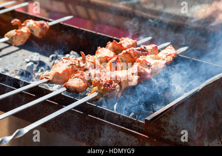 Saftige Scheiben von Fleisch mit Soße vorbereiten auf die heißen Kohlen Stockfoto