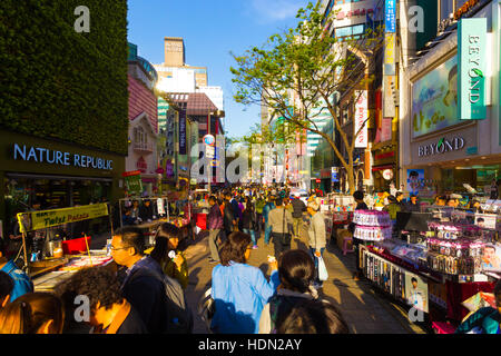 Touristen zu Fuß nach unten schmal Myeongdong Einkaufsstraße mit Kommerz Geschäfte, Schilder und überfüllt mit Menschen o Stockfoto