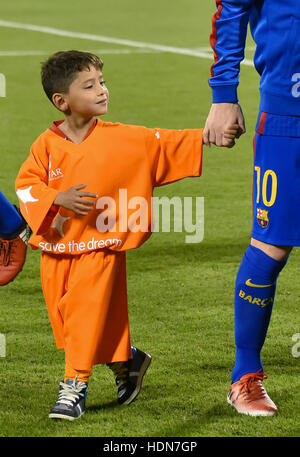 Doha, Katar. 13. Dezember 2016. Afghanischer Junge Murtaza Ahmadi (L) hält die Hand von Barcelonas Lionel Messi auf dem Platz vor dem Start eines freundlichen Fußballspiels gegen Saudi Al-Ahli in Doha, der Hauptstadt von Katar, 13. Dezember 2016. Ahmadi erregte weltweiten Aufmerksamkeit mit Fotografien tragen eine Plastiktüte in blau und weiß mit Messi Namen drauf. Bildnachweis: Nikku/Xinhua/Alamy Live-Nachrichten Stockfoto