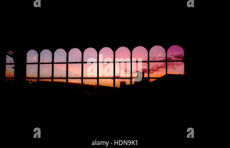 Brighton, Sussex, UK. 14. Dezember 2016. Einen wunderschönen Sonnenaufgang gesehen durch die Fenster des Brighton Railway Station am frühen Morgen mit sonnigem Wetter setzt sich für die Woche Foto von Simon Dack Credit fort: Simon Dack/Alamy Live News Stockfoto