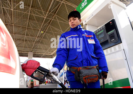 Shijiazhuang, Shijiazhuang, China. 14. Dezember 2016. Ein Arbeiter hilft ein Auto an einer Tankstelle in Shijiazhuang, Hebei-Provinz Nord-China, 14. Dezember 2016 zu tanken. China sah seine größte Benzin- und Dieselpreise in den vergangenen vier Jahren spät vor kurzem angetrieben die Ausgabe schneiden durch OPEC und anderen Herstellern erhöhen. Preise für Benzin und Diesel wurden von 435 Yuan ($63) und 420 Yuan pro Tonne, bzw. nach einer Meldung von der National Development and Reform Commission am 14. Dezember 2015 gewandert. Es war der 24. Preisanpassung für dieses Jahr. (Kredit-Bild: © SIPA Asien vi Stockfoto