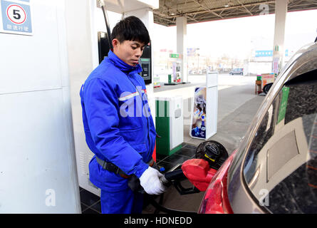 Shijiazhuang, Shijiazhuang, China. 14. Dezember 2016. Ein Arbeiter hilft ein Auto an einer Tankstelle in Shijiazhuang, Hebei-Provinz Nord-China, 14. Dezember 2016 zu tanken. China sah seine größte Benzin- und Dieselpreise in den vergangenen vier Jahren spät vor kurzem angetrieben die Ausgabe schneiden durch OPEC und anderen Herstellern erhöhen. Preise für Benzin und Diesel wurden von 435 Yuan ($63) und 420 Yuan pro Tonne, bzw. nach einer Meldung von der National Development and Reform Commission am 14. Dezember 2015 gewandert. Es war der 24. Preisanpassung für dieses Jahr. (Kredit-Bild: © SIPA Asien vi Stockfoto