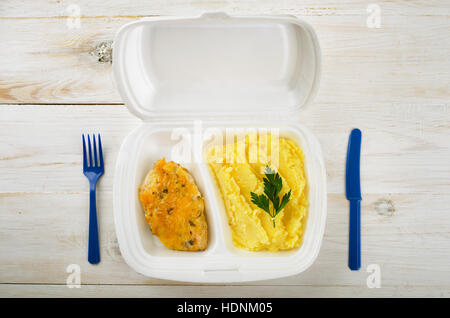 Business-Lunch: Chiken und Kartoffel Püree in Styropor-Paket auf einem Holztisch Stockfoto