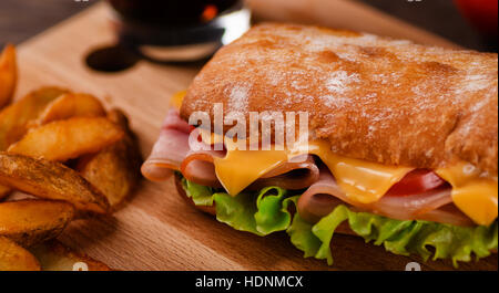 Sandwich mit Kartoffel Wedges frittierte Nahaufnahme am Tisch im restaurant Stockfoto