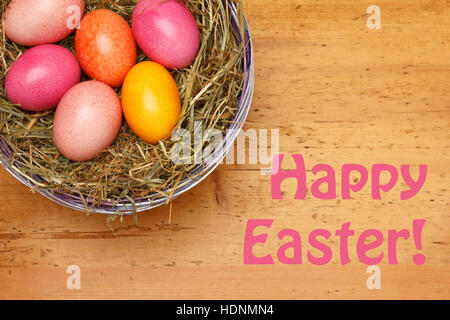 Vorlage Frohe Ostern mit 6 Ostereier in weichen Farben in einem Korb mit Stroh auf eine Vintage Holz-Hintergrund, Retro-design Stockfoto