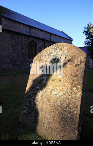 Ein Schatten auf, einen Grabstein von der Statue einer engelhaften Figur auf einem Friedhof. Stockfoto