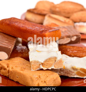 Nahaufnahme von einige Steingut Teller mit verschiedenen Turron und Mantecados Polvorones, typische Weihnachtsgebäck in Spanien, auf einem weißen Hintergrund Stockfoto