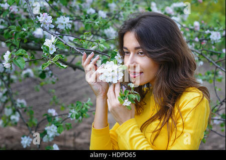 junge schöne Frau in der Nähe von blühenden Frühlingsgarten Baum Stockfoto