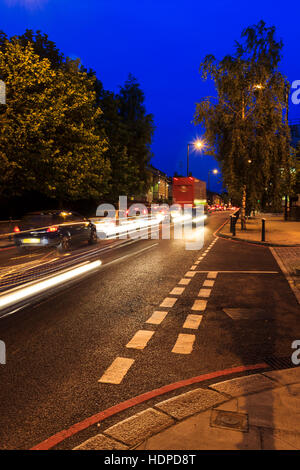 Blau und Orange urbanen Nacht Szene mit einer Motion - verschwommenes beschleunigt Datenverkehr, der eine so der Markierungen im Vordergrund, Archway Road, London, UK Stockfoto