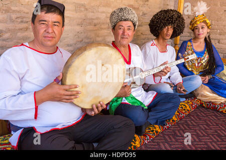 Choresmian Musiker in traditionellen Kleidern spielen und singen lokale Lieder in Chiwa, Usbekistan Stockfoto