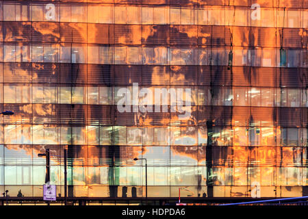 Die Farben des Sonnenuntergangs spiegeln sich in der Glasfassade des Kings Place wider, Heimat der Guardian und Observer Zeitungen, King's Cross, London, Großbritannien Stockfoto