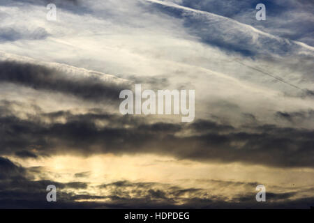 Dunkle Wolken am Himmel bei Sonnenuntergang mit dem Flugzeug Kondensstreifen Stockfoto