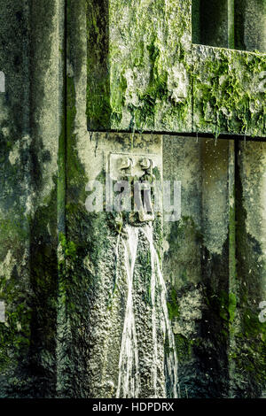 Grün getönten Close-up og Fliegen und Mücken, die um einen sprudelnden Überlauf Schleuse auf der Themse Embankment, London, UK Stockfoto