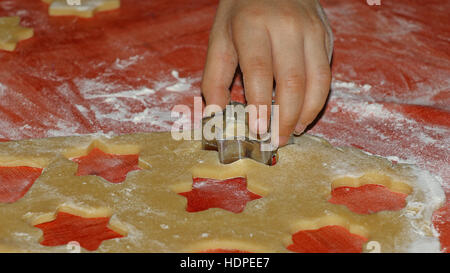 Sterne geformte Ausstecher in die Hände des Kindes Ausschneiden Weihnachtsplätzchen Stockfoto