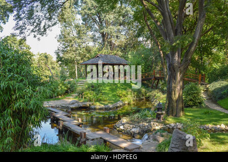 Ruhigen und romantischen japanischen Garten mit schönen Teich und Holzbrücke am sonnigen Tag Stockfoto