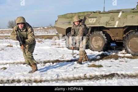 US-Soldaten absteigen ein BTR gepanzerten Fahrzeug während einer unterdrückerischen Feuer-Übung im International Peacekeeping and Security Center 18. November 2016 in Yavoriv, Ukraine. Stockfoto