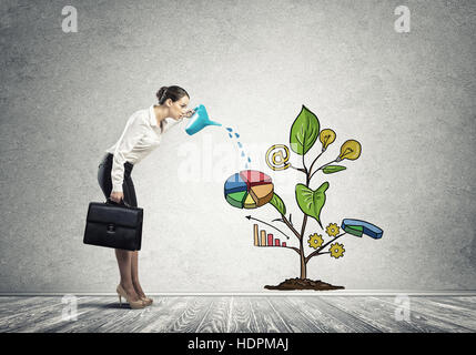 Junge Geschäftsfrau in leeren Raum Gießen gezeichnete Wachstumskonzept mit can Stockfoto