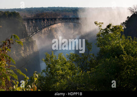 Ansichten der Victoriafälle. Hinter der Brücke zwischen Sambia und Simbabwe.  Seit mehr als 50 Jahren wurde die Brücke regelmäßig durch Personenzüge gekreuzt. Stockfoto