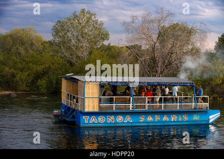Kreuzfahrt entlang der Victoria Falls an Bord der "African Queen".  Andere Boote Segeln in den Sambesi. Die Sonnenuntergangsfahrten variieren in Bootsgröße – von es Stockfoto