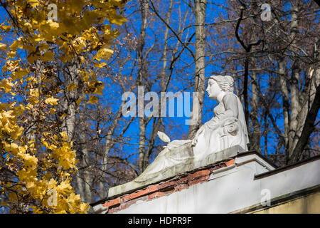 Skulptur einer Frau mit einem Spiegel in der Hand, umgeben von Herbst Laub Keil Stockfoto