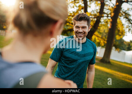 Schuss von schön und Fit junger Mann lächelnd mit Frau im Park. Junges Paar im Park. Stockfoto